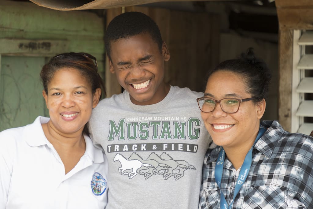 Esperanza, Julio and Isabel pose for a close-up photo of the three of them smiling.