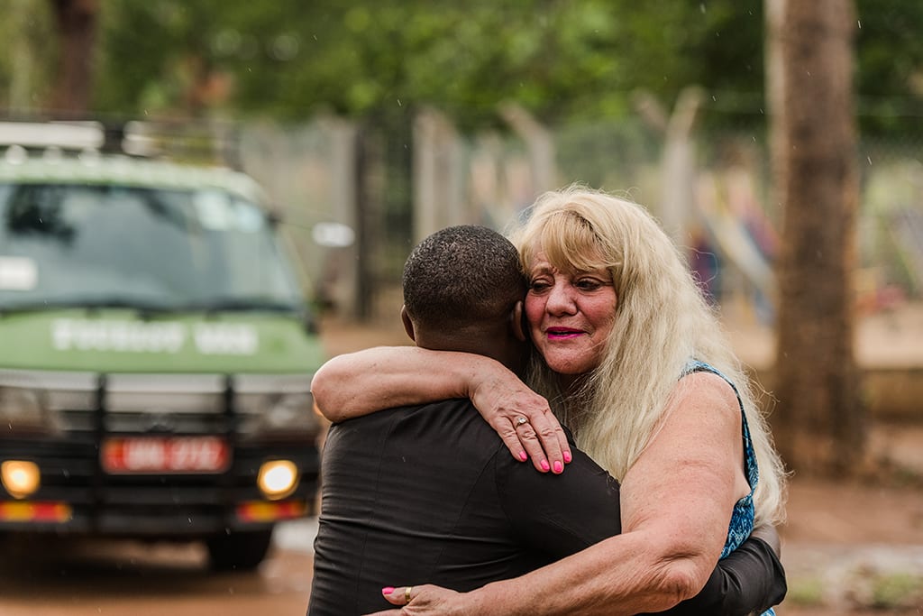 Cynthia hugs the young woman that she and her husband sponsor in Uganda.