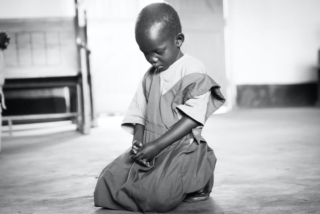 A child kneeling in prayer.