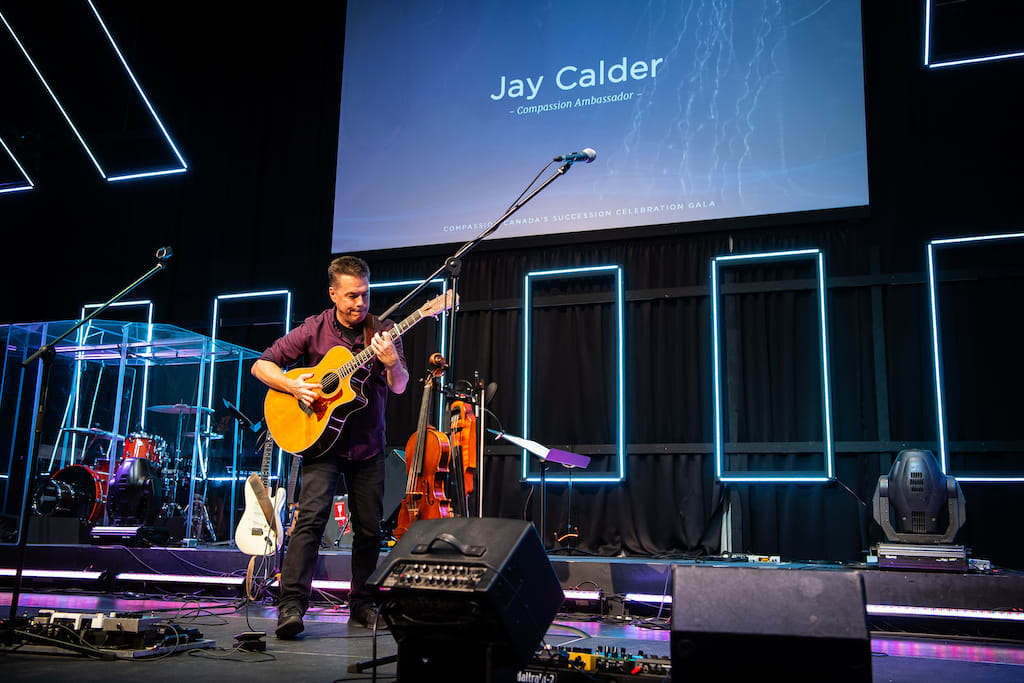 Jay Calder plays guitar on stage.