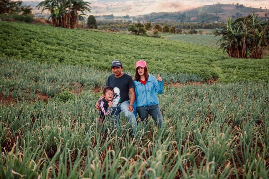 Karunia and her parents pose in the fields