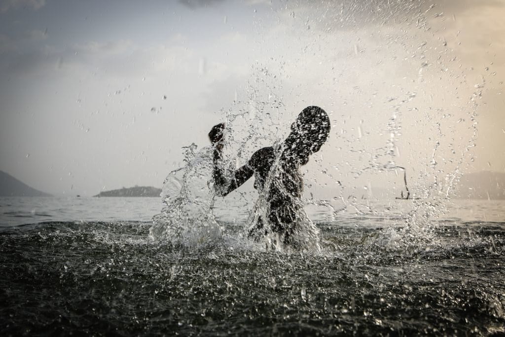 A boy splashes in the water.