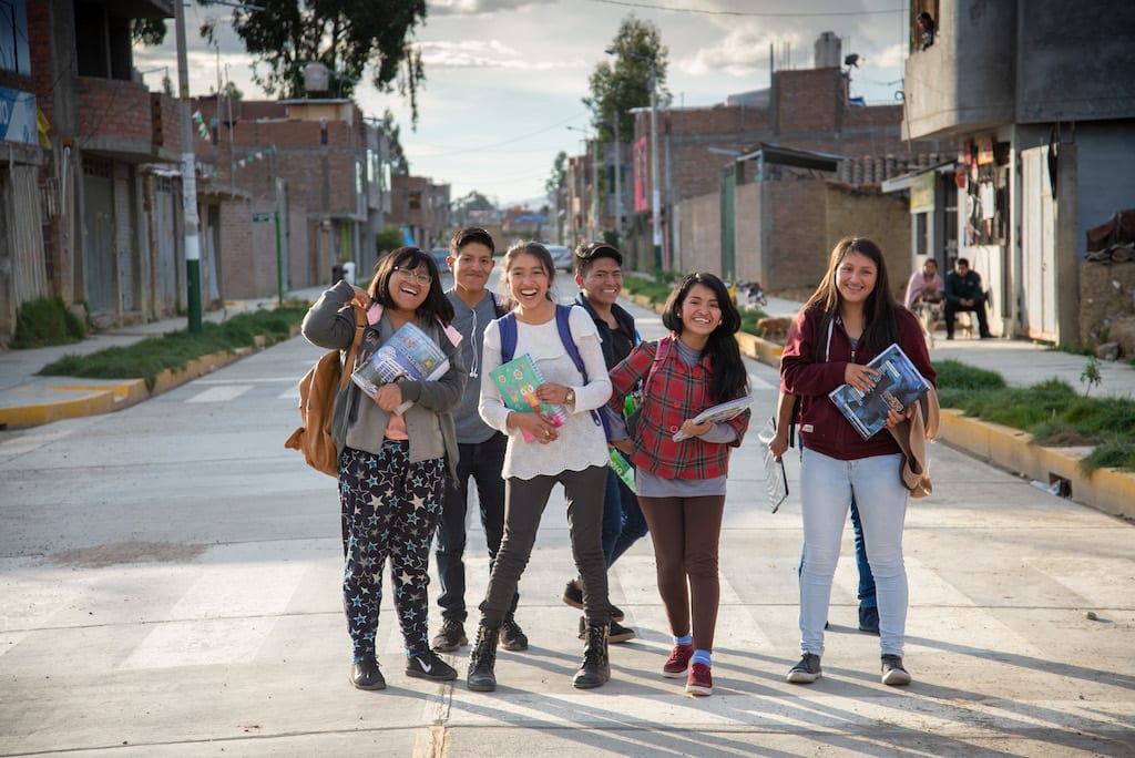 A group of students smiling in the street.