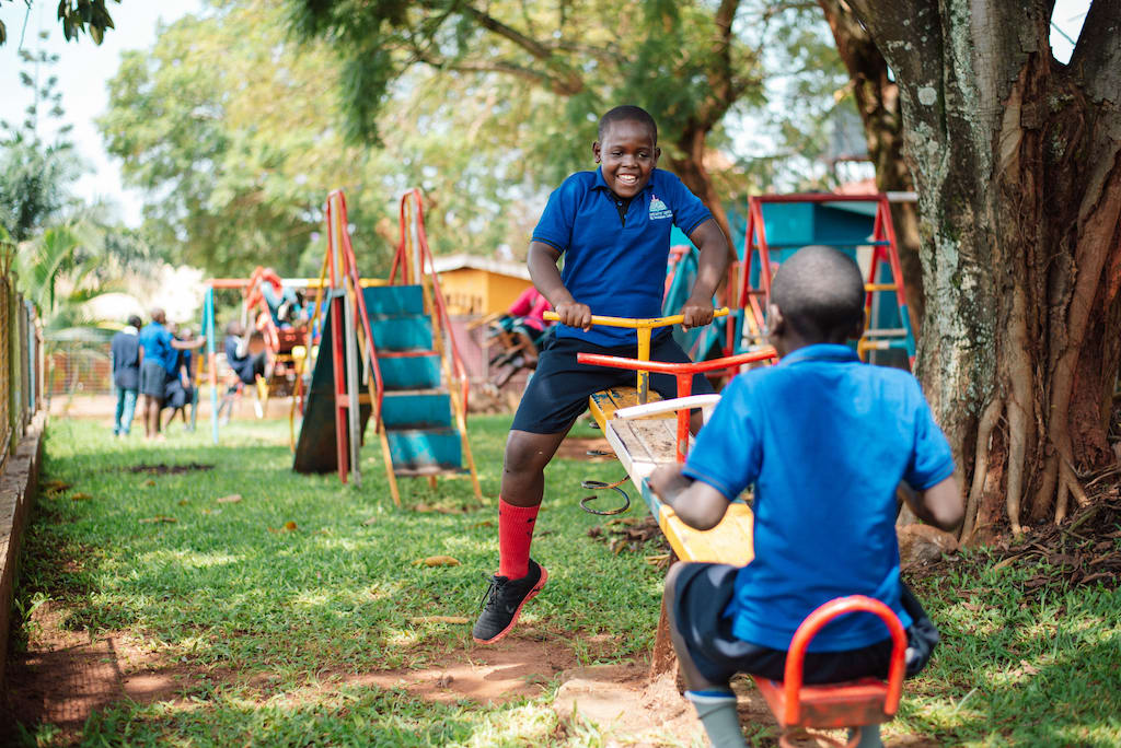 Children in Uganda play on a seesaw.