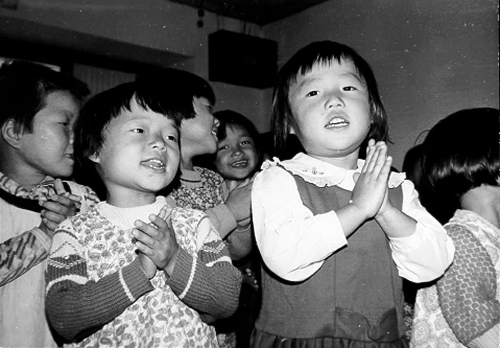 A black and white photo of two Korean girls in a children's program.