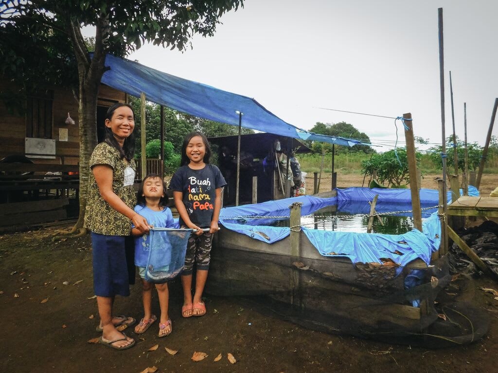 The family poses infront of their fish pond.