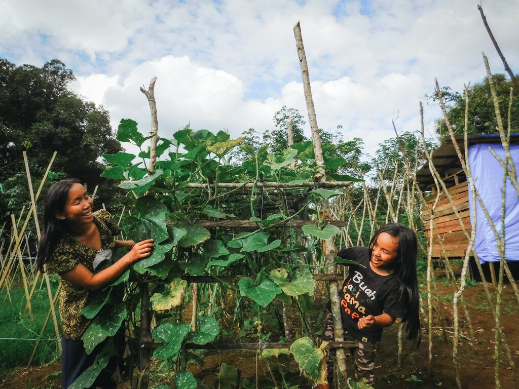 Meisy and her mom, Lusiana, working in their bean garden.