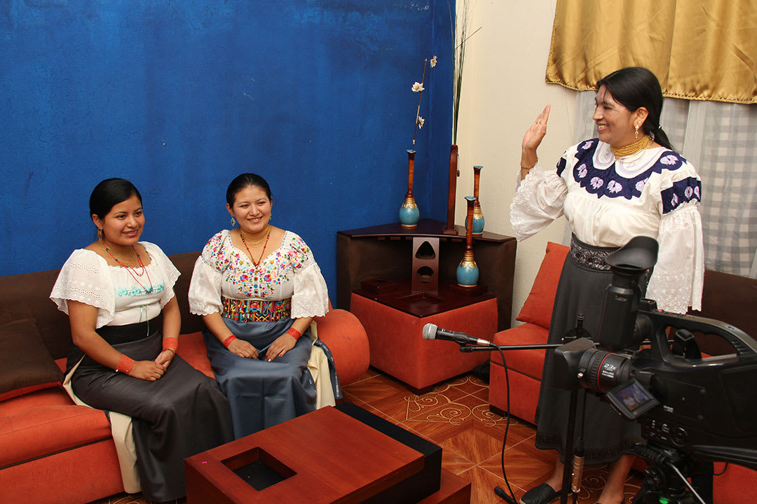 Two Ecuadorian women sit in front of a video camera as Viviane directs them.