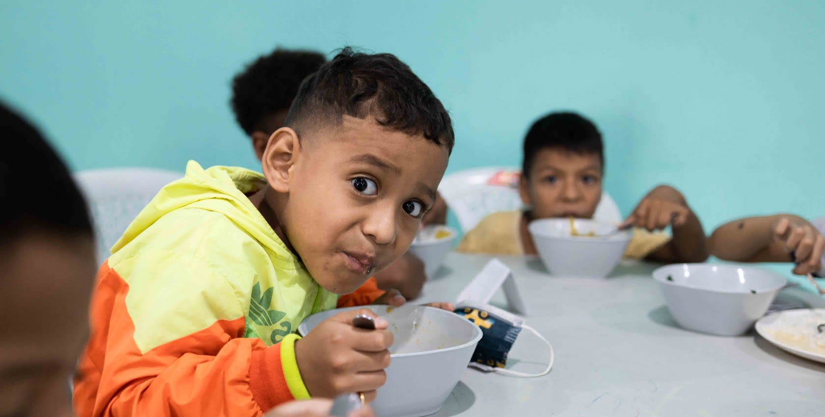 A child dining with a bowl in his hand.