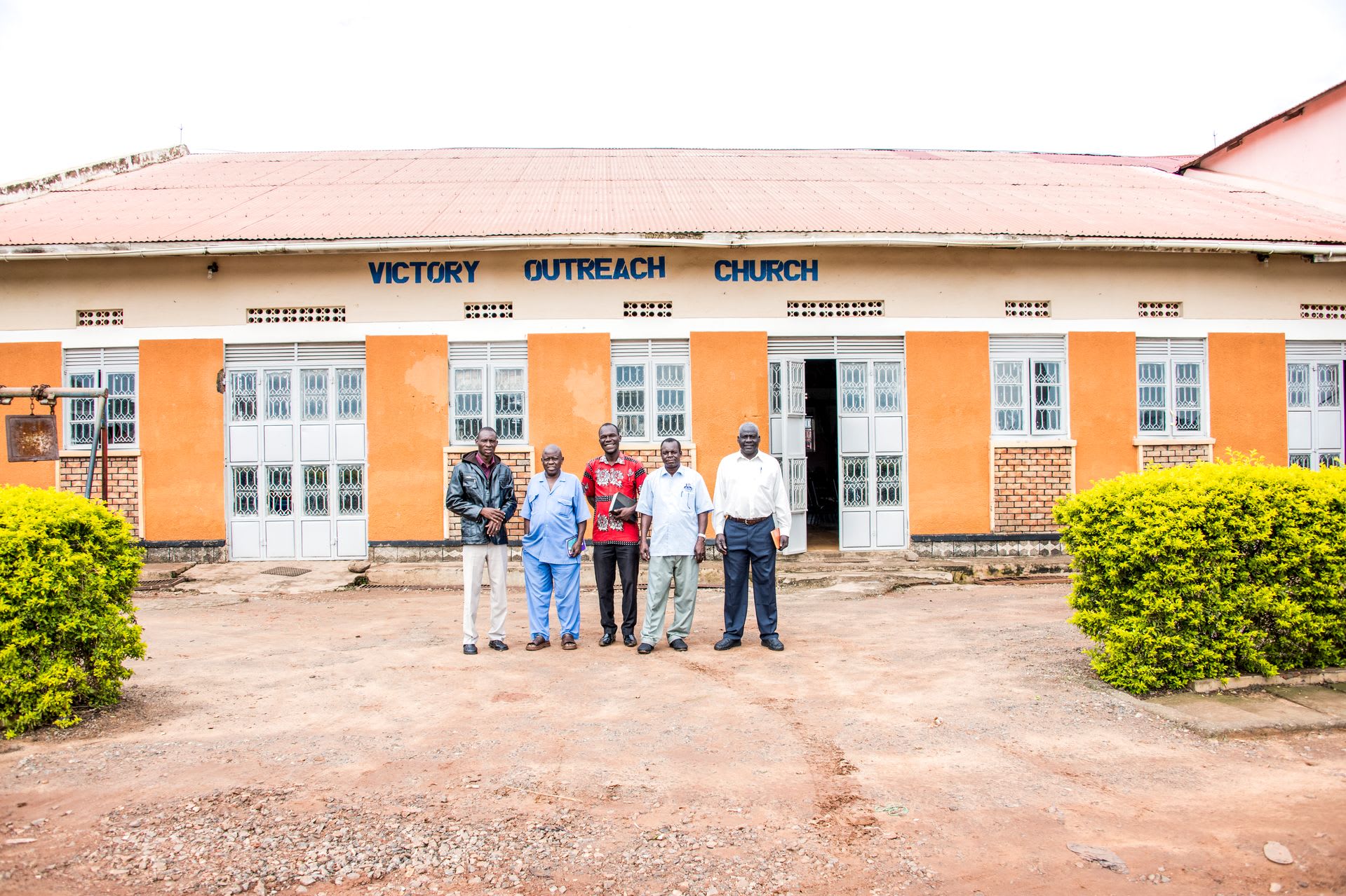 Five men in front of Victory Outreach Church