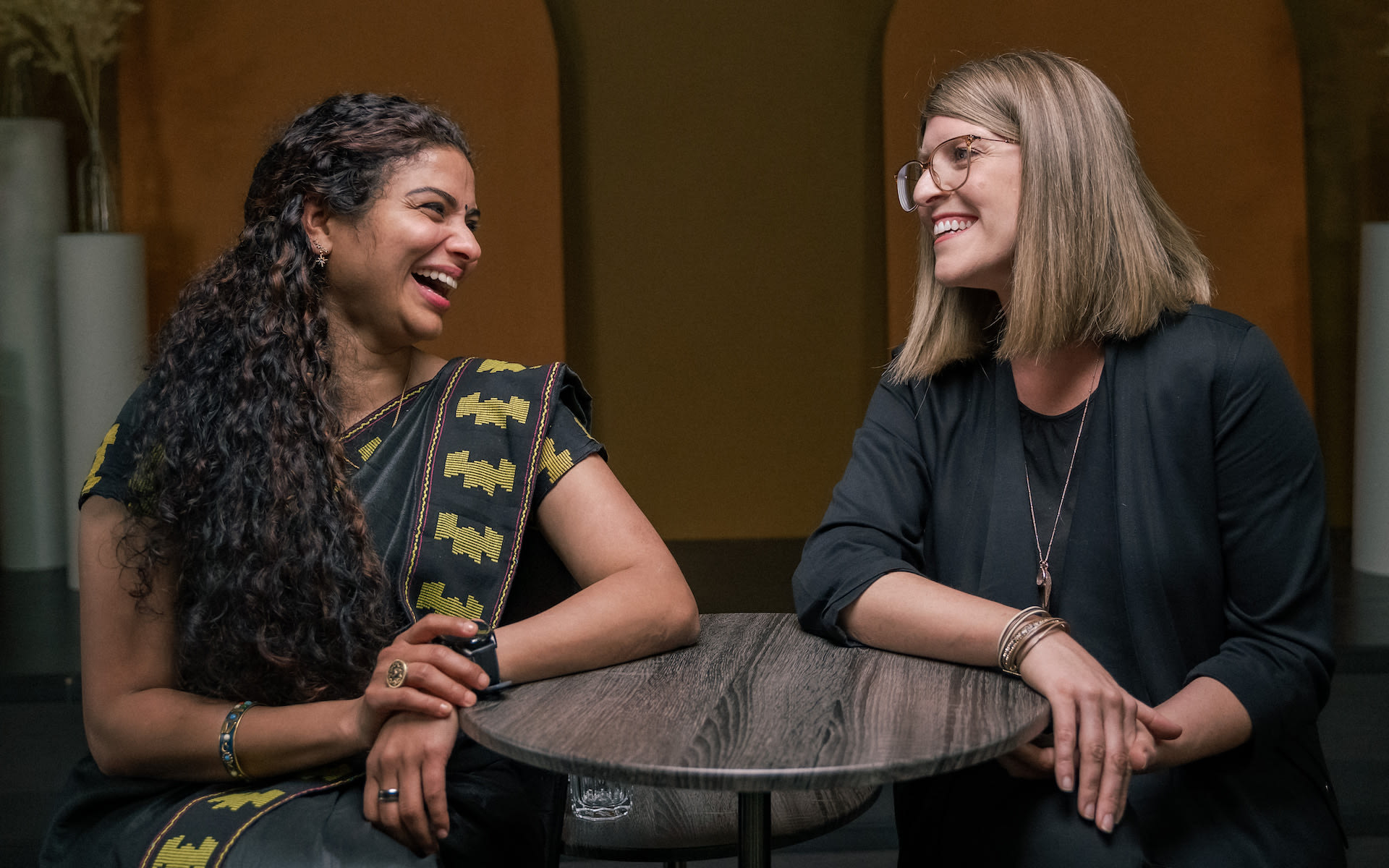 Anu and Allison sit together at a table.
