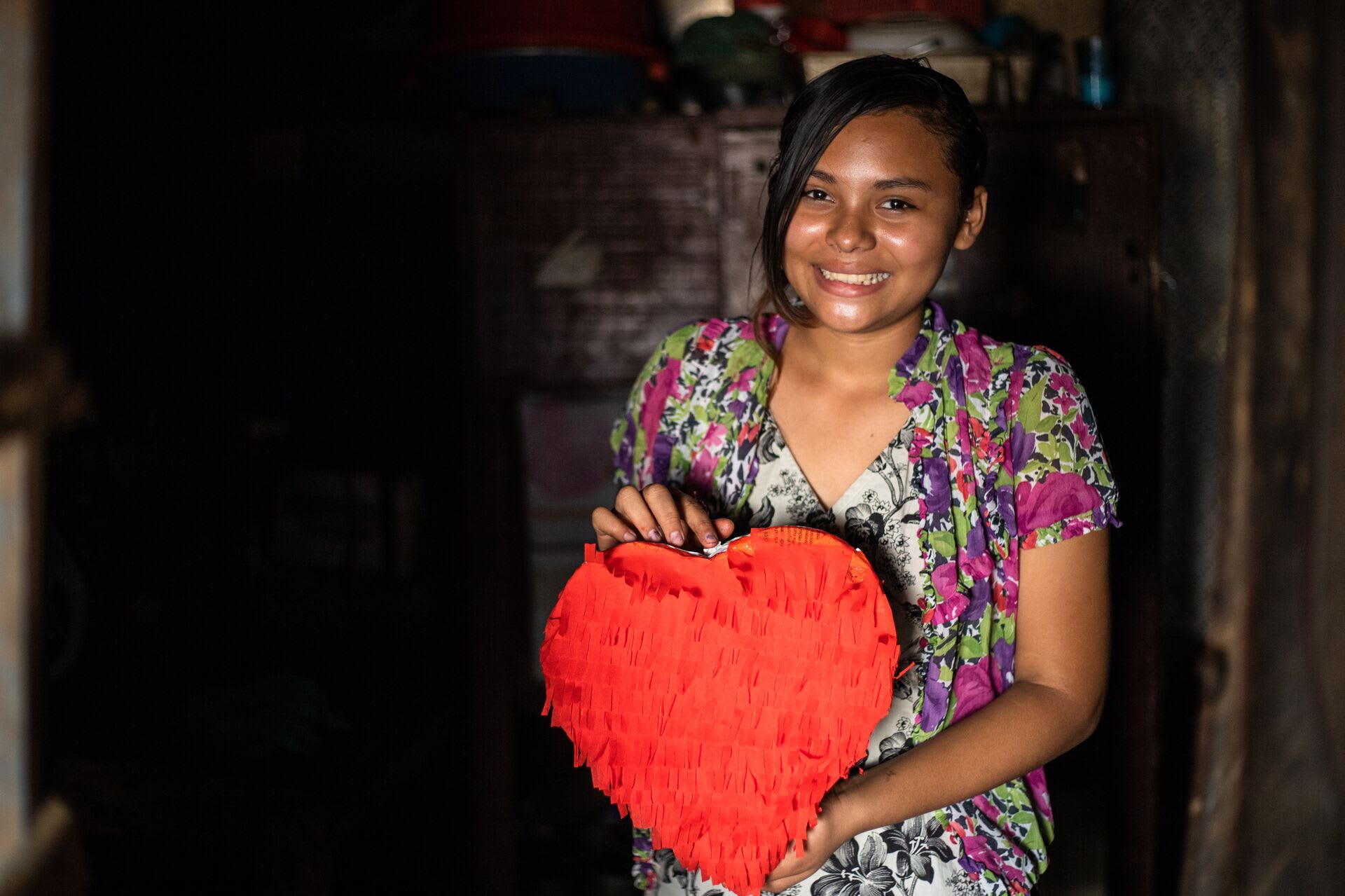 Estella poses with a heart pinata she made