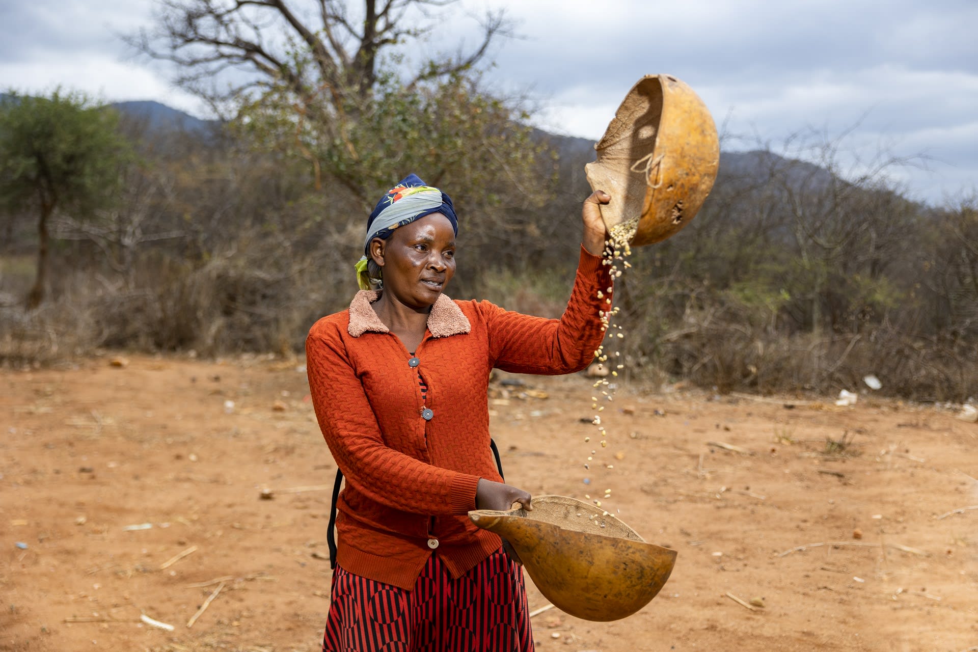 Woman pouring beans from one gourd to another