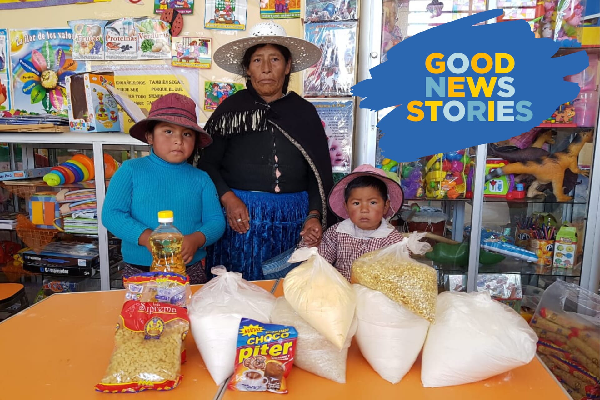 A woman and two children pose with a grocery delivery provided by Compassion.