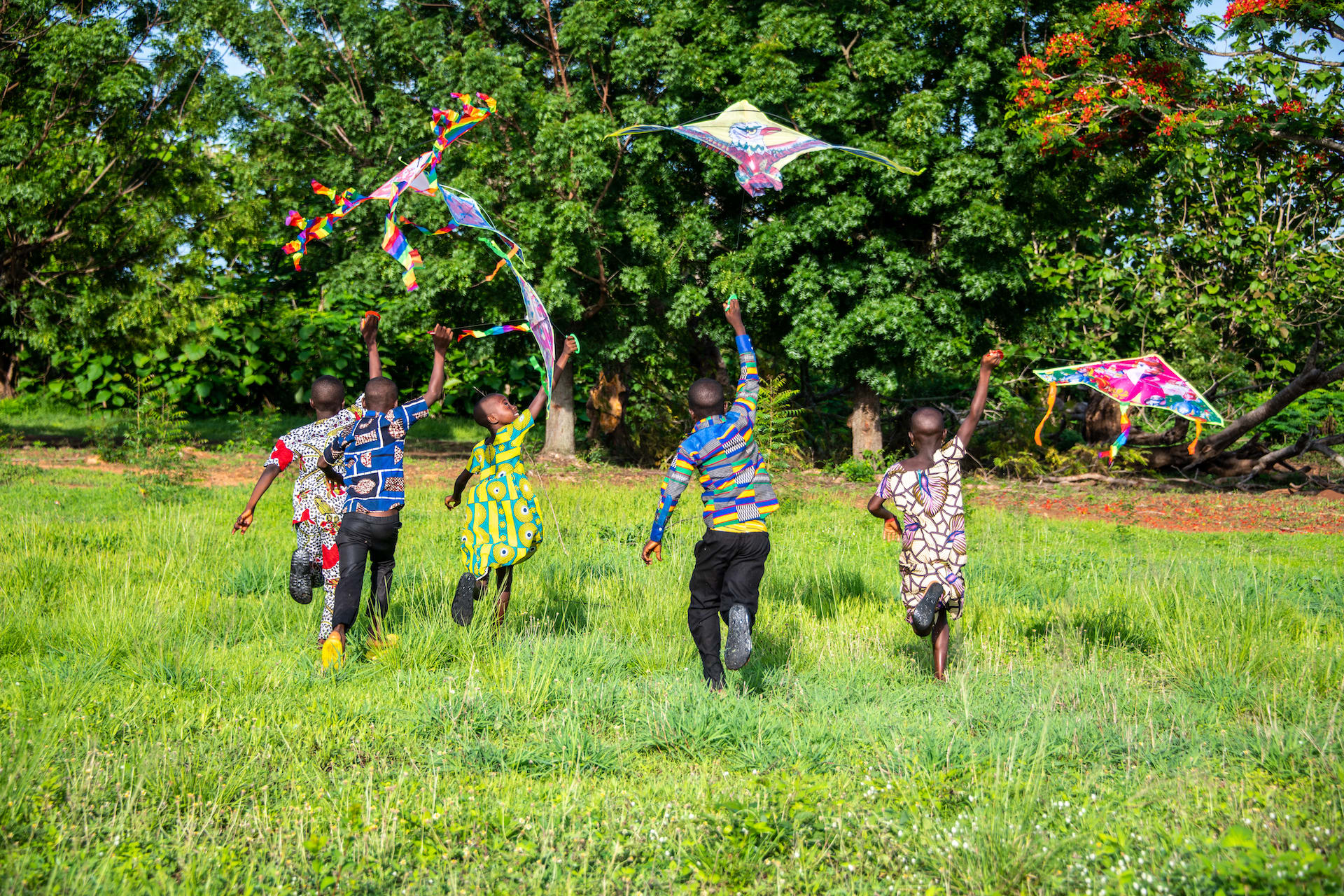 Children flying kites in a field in Togo