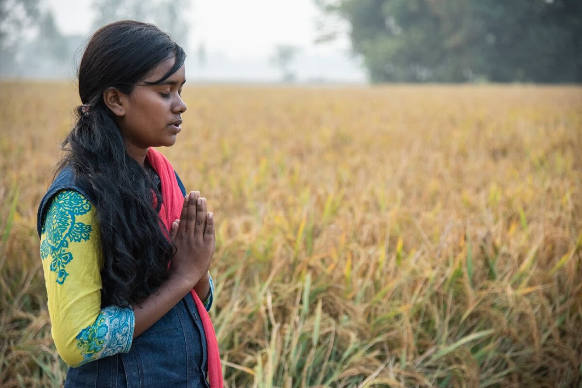 A girl standing to pray