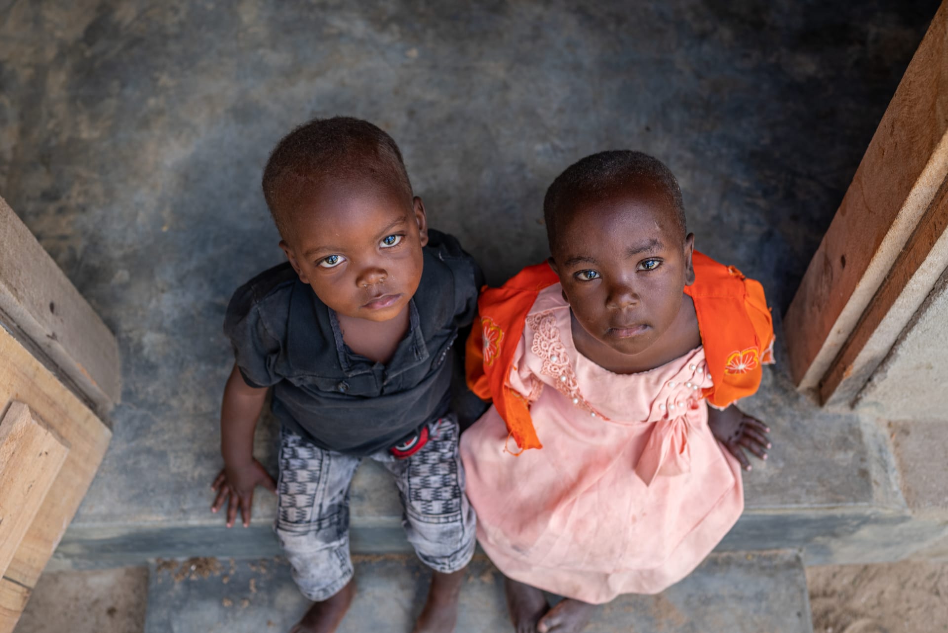 twins - a boy and a girl stare intently up at the camera