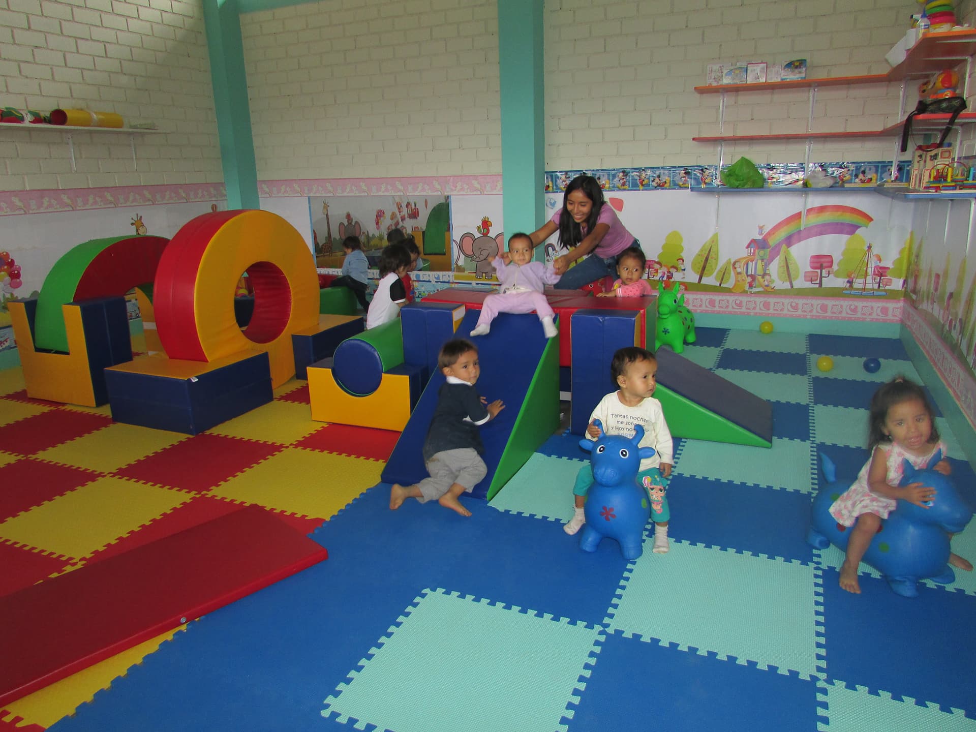 Kids play on colourful indoor playground.