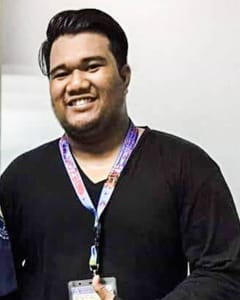 A picture of a Filipino man in a black sweater giving a thumbs up.