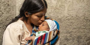 A mother kissing her child