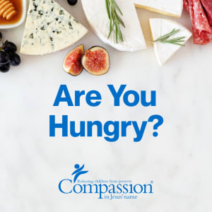 various delicious and decadent foods are displayed on a marble countertop. This is the title image for Compassion Canada's Are You Hungry devotional.