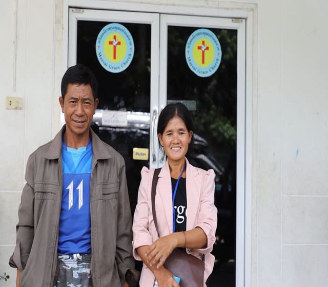 The happy parents of the sponsored boy who has been rescued from the cave in Thailand standing outside of the church where their son attends the Compassion program.