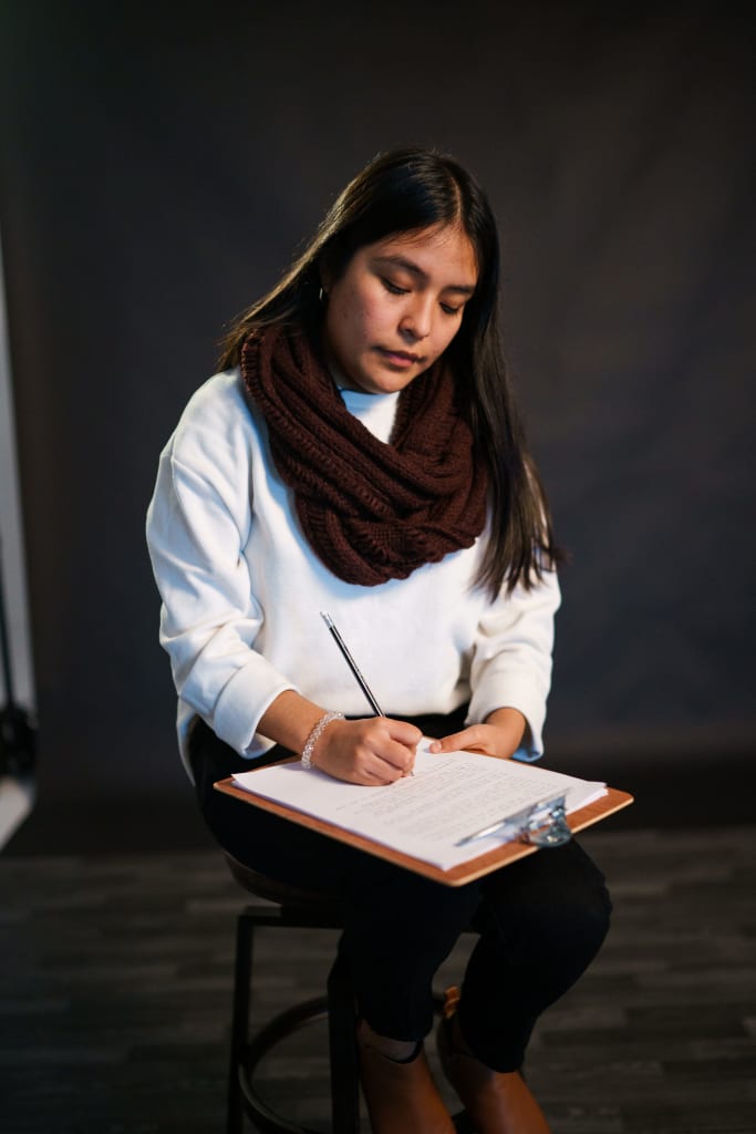 Liz, a young Peruvian woman, is writing a letter to her sponsor