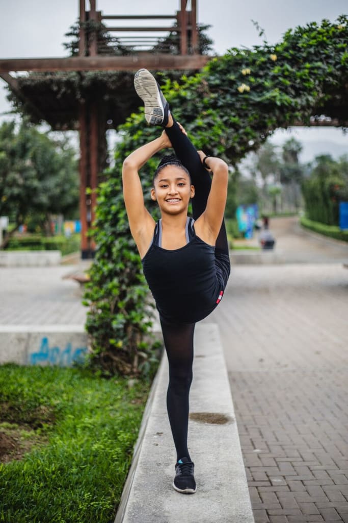 A young girl striking a gymnastic pose.