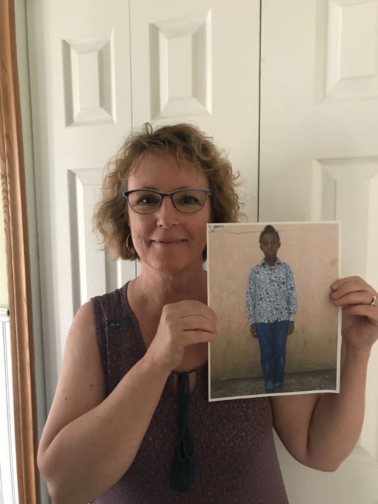 Karen holds a printed off photo of her sponsored child