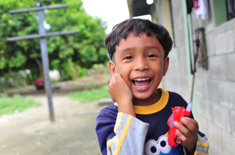 A young Guatemalan boy holding a toy car